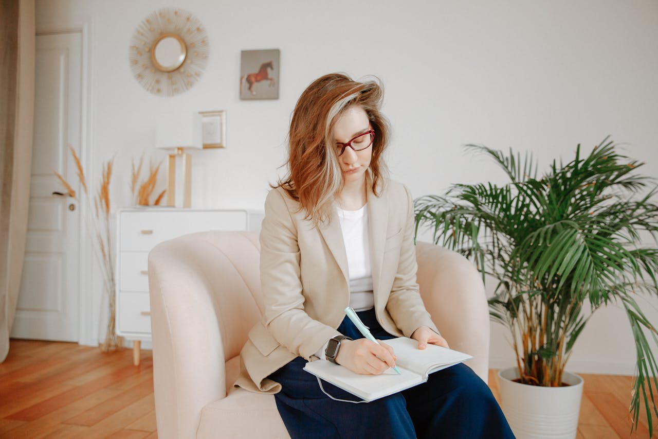 A female therapist taking notes during a session in a stylish office setting.